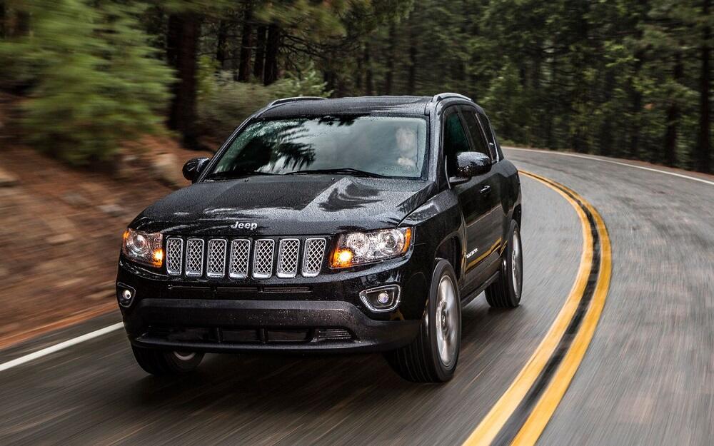 Jeep Compass черного цвета едет по дороге
