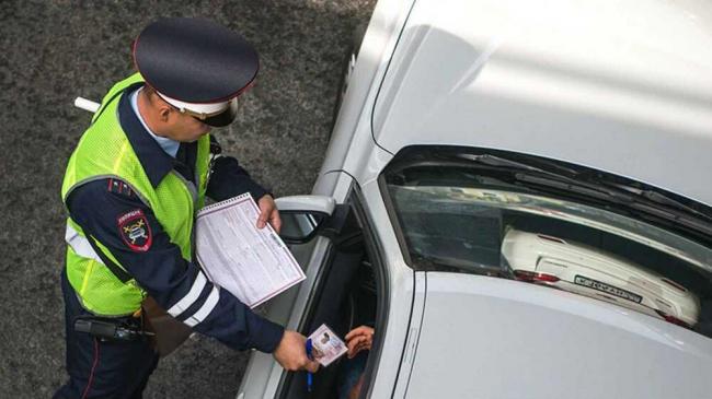 Сотрудник ДПС держит в руках протокол штрафа