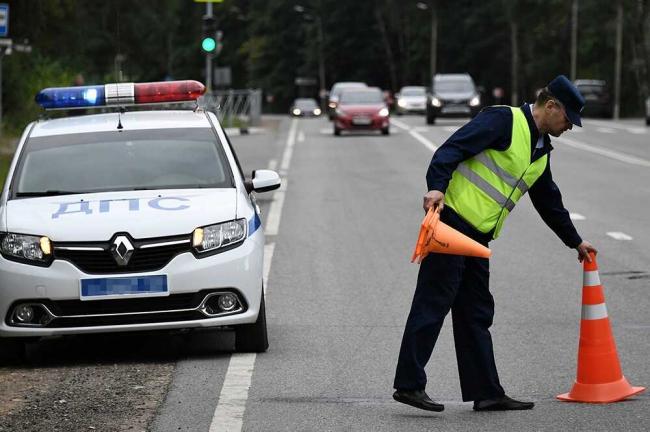 Сотрудник ДПС выставляет конусы на месте ДТП